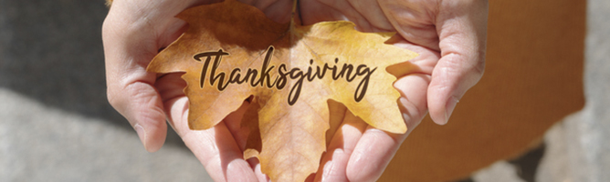 Thanksgiving text on maple leaf in a woman's hands