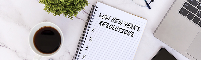 New Year's Resolutions 2021 text on note pad with smart phone, laptop, coffee, eyeglasses and pen
